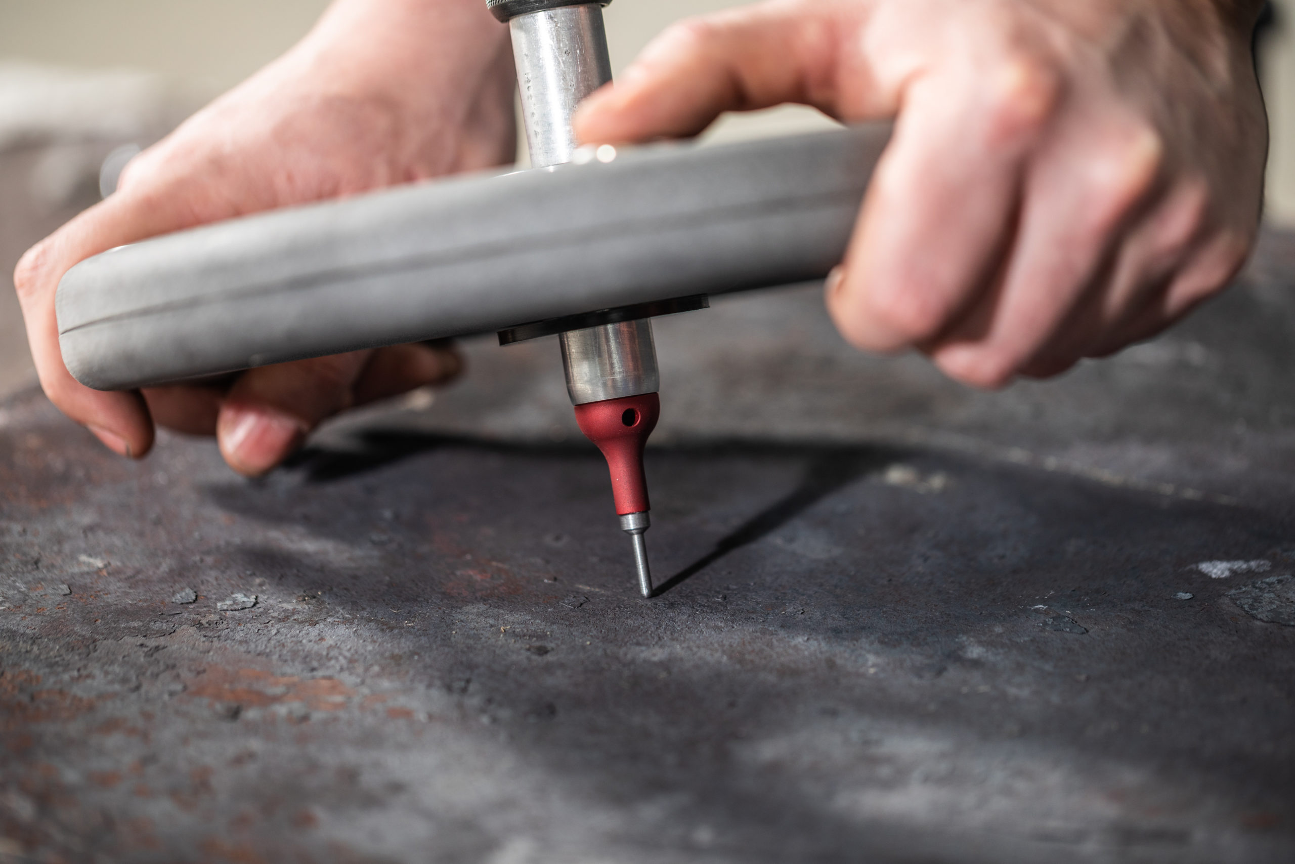 Two hands carrying out Brinell hardness test